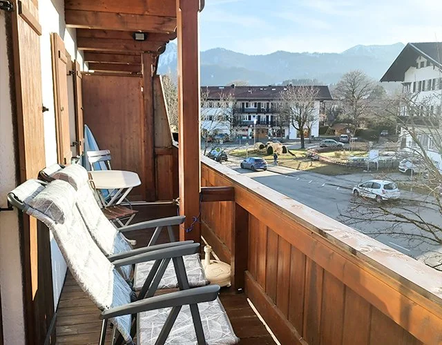 Balcony seating overlooking snowy alpine surroundings.