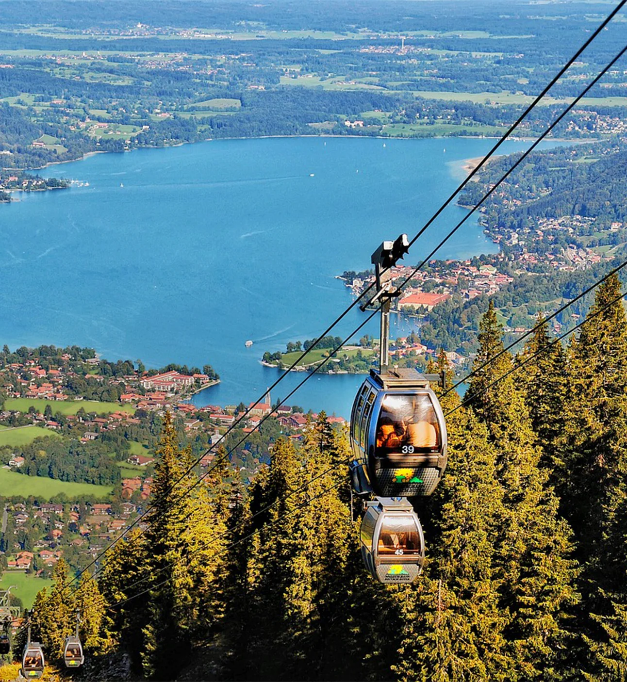 Cable car moving over the valley and lake scenery.